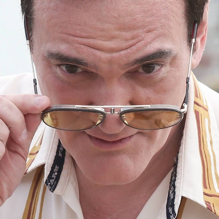 Quentin Tarantino 2019. Er neigt den Kopf nach vorne und schaut uns über seine Sonnenbrille hinweg an