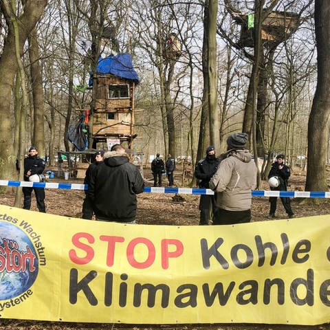 Nordrhein-Westfalen, Düsseldorf: Ein Plakat "Stop Kohle & Klimawandel" hängt vor einer Polizeiabsperrung im Hambacher Forst.