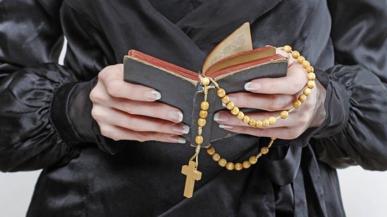 Hände halten Bibel und Rosenkranz (Foto: IMAGO, BE&W)