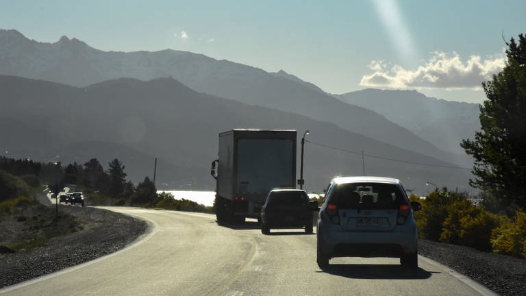 Strasse in Patagonien mit PKW und LKW. Im Hintergrund hohe Berge. (Foto: SWR, Walter Filz)