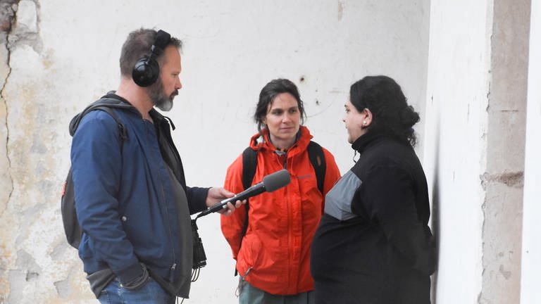 Mann mit Mikrofon steht vor zwei Frauen. (Foto: SWR, Walter Filz)