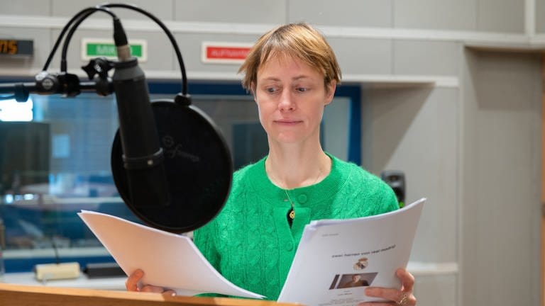 Katharina Marie Schubert mit Manuskript in der Hand vor dem Mikrofon