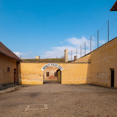 Verwaltungshof im Konzentrationslager Theresienstadt, im Hintergrund das Tor zum Konzentrationslager mit der Aufschrift: Arbeit macht frei (Foto: IMAGO, Jan Huebner)