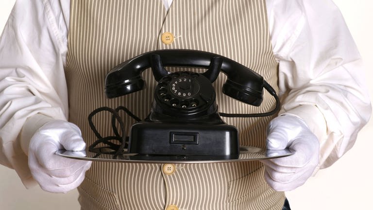 Butler bringt ein altes Telefon 