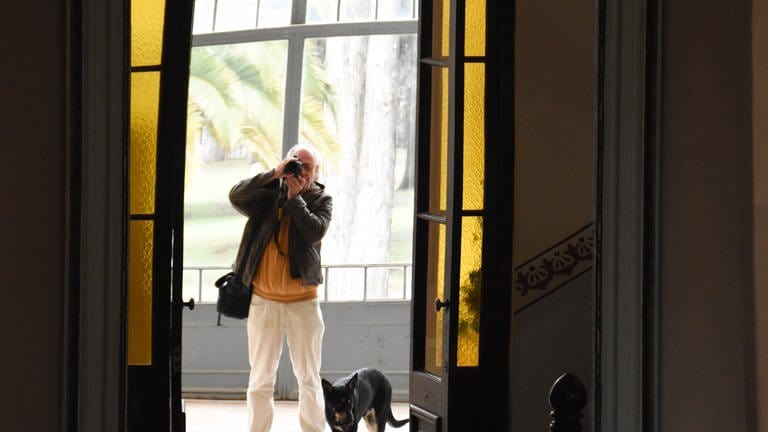 Mann fotografiert in einen Spiegel. Neben ihm steht ein Hund. (Foto: SWR, Walter Filz)