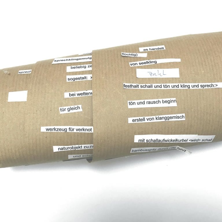 Eine Papierrolle mit ausgeschnittenen Satzfragmenten - die sogenannte Metamaschine