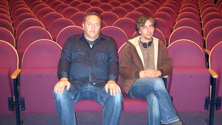 Die Karl-Sczuka-Preisträger 2008 Thomas Meinecke und David Moufang, sitzend auf roten Kinosesseln