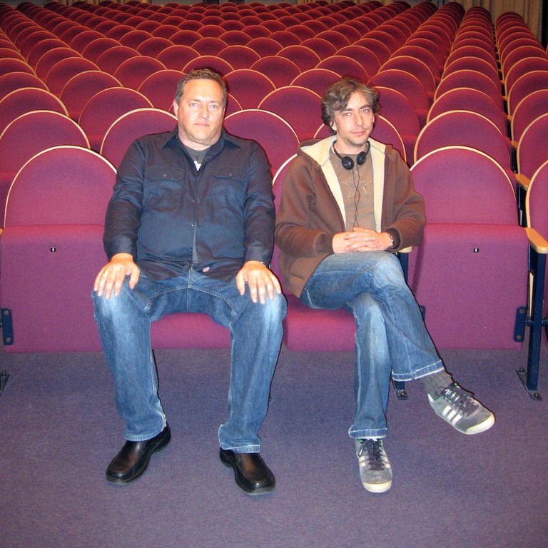 Die Karl-Sczuka-Preisträger 2008 Thomas Meinecke und David Moufang, sitzend auf roten Kinosesseln