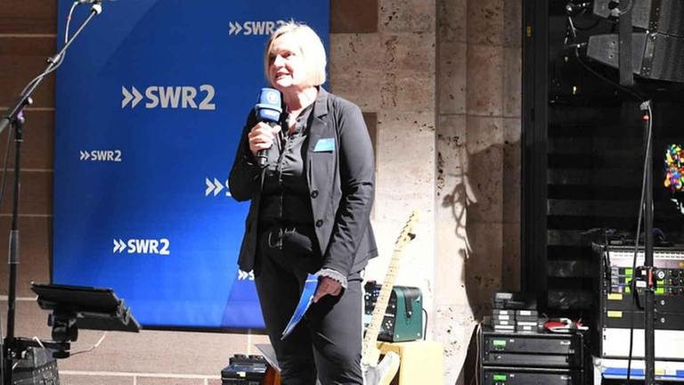 Silke Arning von SWR2 steht mit dem Mikrofon auf der Bühne (Foto: SWR, SWR, Brzezinski -)