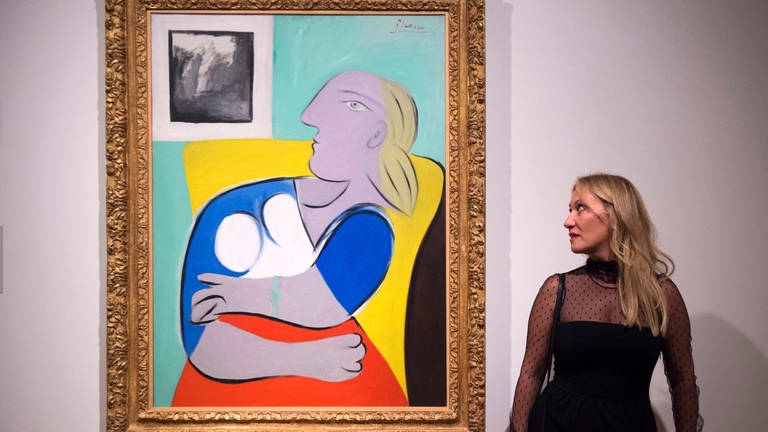 Diana Widmaier Picasso, granddaugther of Spanish painter and sculptor Pablo Picasso, poses next to a painting of her grandmother Marie-Therese Walter called 'Woman in the Yellow Armchair' (Foto: picture-alliance / Reportdienste, dpa | Will Oliver)