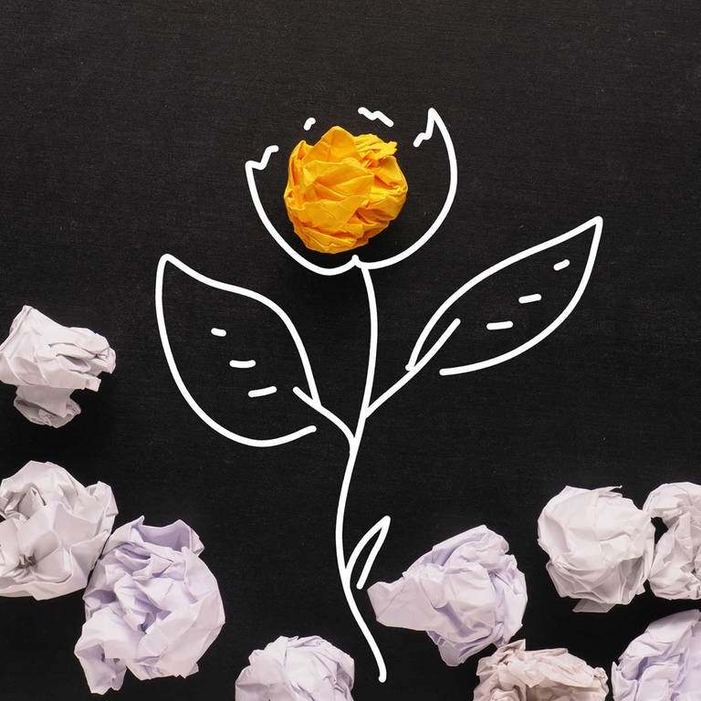 Papierknäuel auf einer gezeichneten Pflanzenblüte (Zeichnung ist mit weißen Konturen auf schwarzes Papier gezeichnet.)  (Foto: picture-alliance / Reportdienste, Foto: Andreas Berheide)