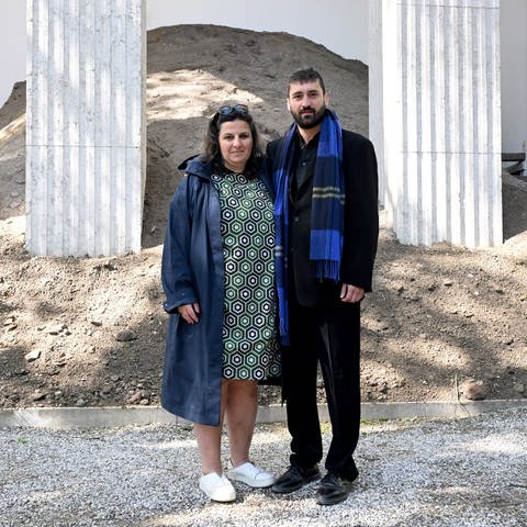Der Künstler Ersan Mondtag steht mit der Kuratorin Çağla Ilk (l) vor dem Deutschen Pavillion beim Pre-Opening im Giardini auf dem Gelände der Kunstbiennale in Venedig.