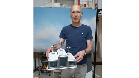 Frank Kunert mit einem seiner Miniaturmodelle im Bopparder Atelier.