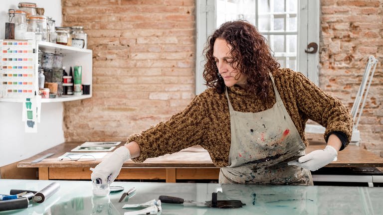 Eine Künstlerin bereitet einen Kunst-Druck in ihrem Atelier vor  (Foto: IMAGO, imago images / Cavan Images)