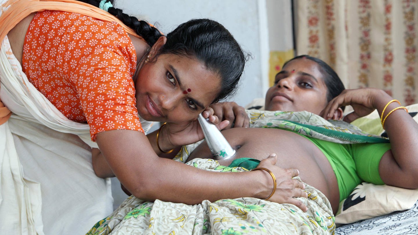 Indien - Mit einem Hebammenstethoskop horcht eine Hebamme den Bauch einer jungen Frau ab (Foto: IMAGO, Stefan Trappe)