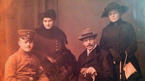 Johann Dötsch sitzend in Uniform, hinter ihm steht seine Schwester, neben ihm sitzt sein Vater und rechts dahinter steht die Mutter - alle tragen Hüte bzw. Uniformmützen