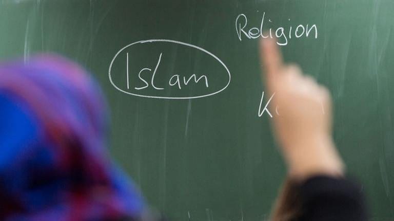 Eine Schülerin mit Kopftuch meldet sich in einer Unterrichtsstunde zum Thema Islam (Foto: picture-alliance / dpa, picture-alliance / dpa - Frank Rumpenhorst)