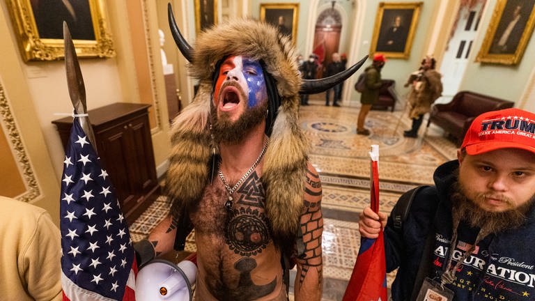 Ein Trump-Unterstützer mit Hörnern und im Bison-Kostum stimmt einen Sprechchor vor der Senatskammer im US Kapitol an.