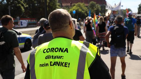 Ein Ordner mit der Aufschrift "Coronadiktatur nein danke" auf der Sicherheitsweste