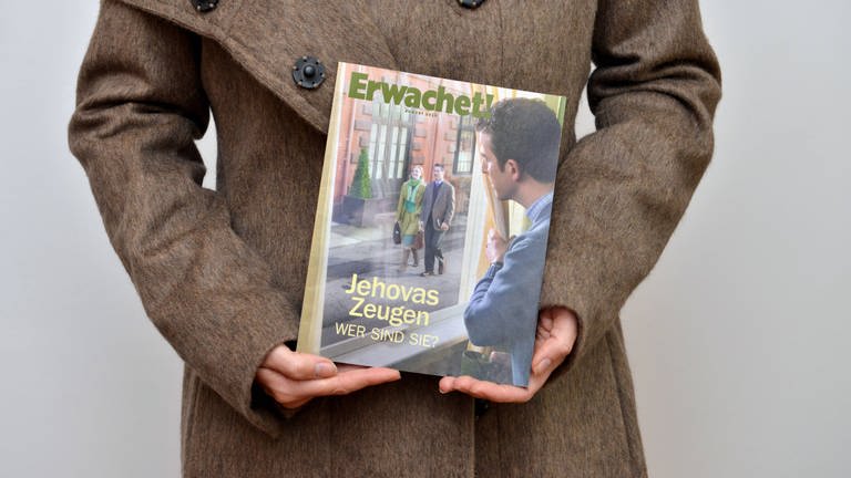 Zeuge Jehovas mit Broschüre Erwachet