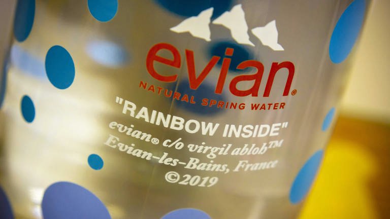 Nahaufname einer von Virgil Abloh designten Evian-Flasche, darauf gedruckt zwischen bunten Punkten "Rainbow Inside" evian co Virgil Abloh. (Foto: IMAGO, IMAGO / Levine-Roberts)