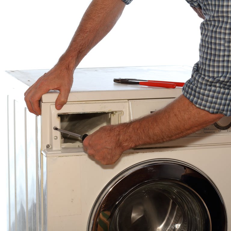 Arbeiter repariert eine Waschmaschine (Foto: IMAGO, IMAGO / Panthermedia / rtbilder)