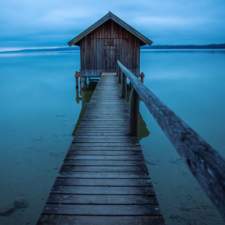 Bootshaus an See in romantischer Landschaft (Foto: IMAGO, Michael Eichhammer)