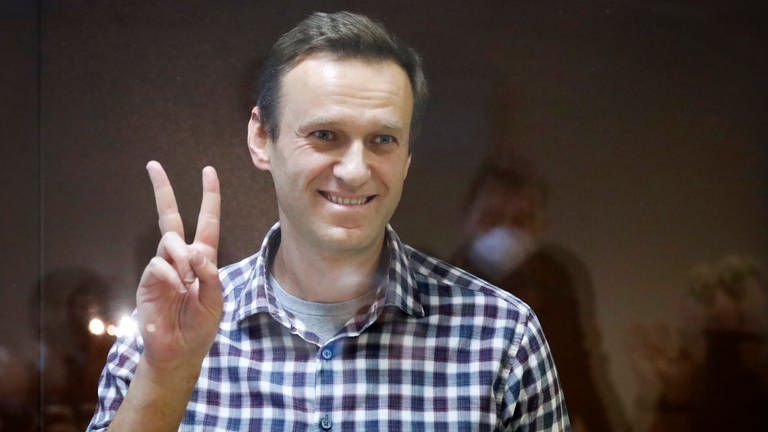 Alexej Nawalny, russischer Oppositionsführer, zeigt das Peace-Zeichen, während er in einem Käfig im Bezirksgericht Babuskinskij steht. (Foto: dpa Bildfunk, picture alliance/dpa/AP)