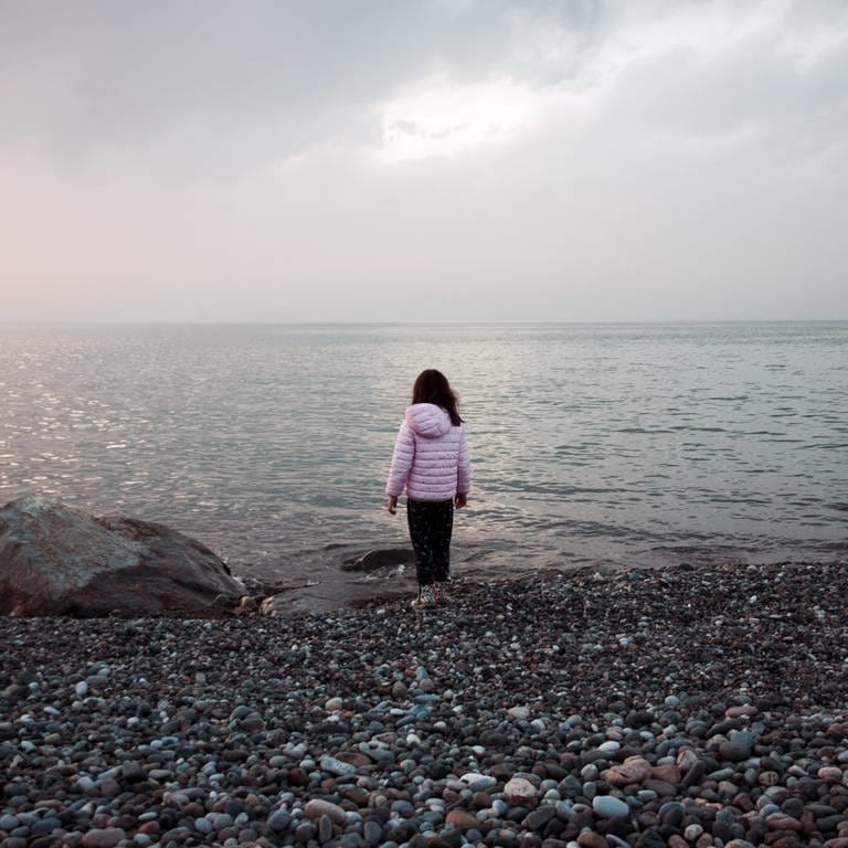 Kleines Mädchen steht einsam am Wasser (Foto: IMAGO, IMAGO / Panthermedia)