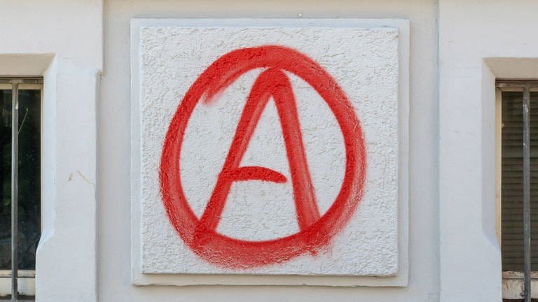 Ein Anarchie-A ist als Graffiti an eine Hauswand gesprüht.