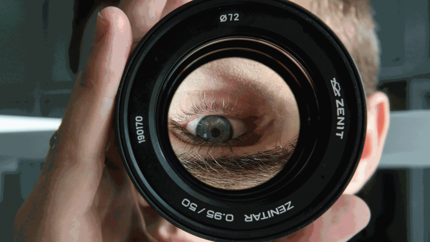 Mann blickt durch ein Objektiv (Foto: IMAGO, ITAR-TASS)