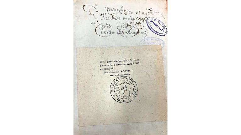 Moshe Rosenfeld fand es in einem Kloster, mit dem Eintrag Berchtesgaden 4.5.1945, darunter das Signet des französischen Klosters. Oben rechts der Stempel einer Religionsschule in Israel, wo sich das Buch heute befindet. (Foto: Igal Avidan)