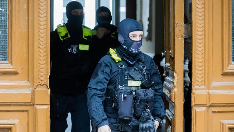 Polizisten kommen bei einer Hausdurchsuchung in Berlin-Kreuzberg aus einem Gebäude. (Foto: dpa Bildfunk, picture alliance/dpa | Christoph Soeder)