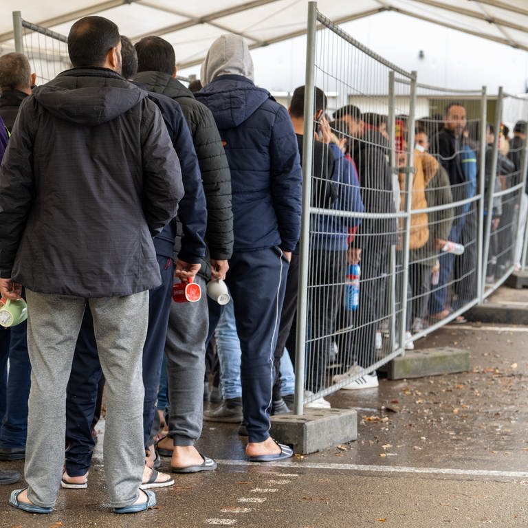 In der Landeserstaufnahmestelle (LEA) warten Flüchtlinge in einer Schlange vor der Essensausgabe.  (Foto: picture-alliance / Reportdienste, picture alliance/dpa | Stefan Puchner)