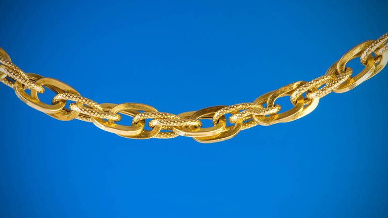 Golden chain isolated on the blue background Symbolfoto