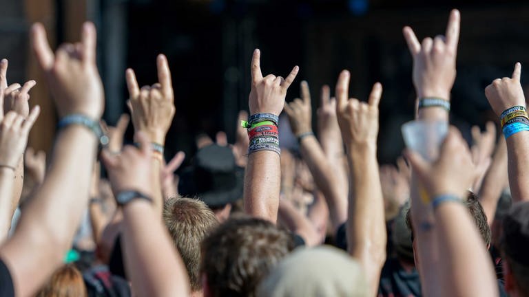 Metal-Fans feiern am 05.08.2016 in Wackenauf dem Festivalgelände des Wacken Open Air mit dem Metal-Gruß, der sogenannten Pommesgabel. 