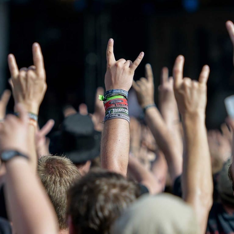 Metal-Fans feiern am 05.08.2016 in Wackenauf dem Festivalgelände des Wacken Open Air mit dem Metal-Gruß, der sogenannten Pommesgabel.  (Foto: picture-alliance / Reportdienste, dpa | Axel Heimken; usage Germany only)