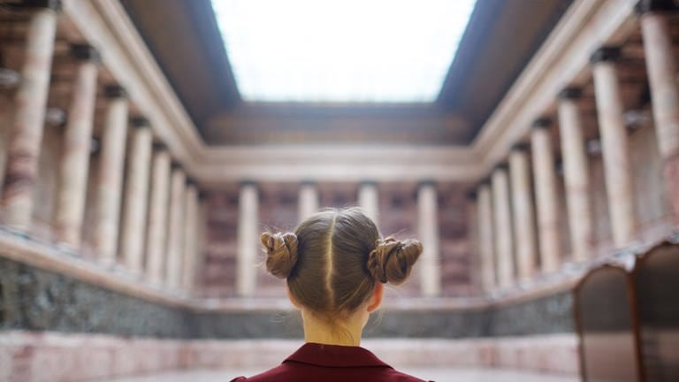 Ein Mädchen von hinten in einem Museum  (Foto: IMAGO, IMAGO / Pond5 Images)