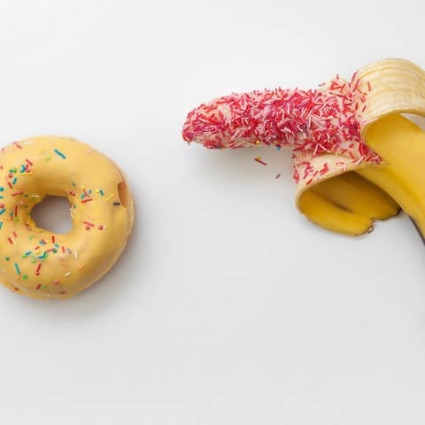 Eine Banane und ein Donut liegen nebeneinander. Symbolfoto für das Buch "Porno" 