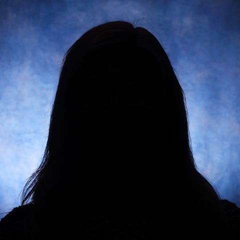 Silhouettes of a female head on a blue background Symbolfoto