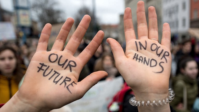 Zwei Handflächen sind zu sehen, auf denen steht "Our Future in our hands" 