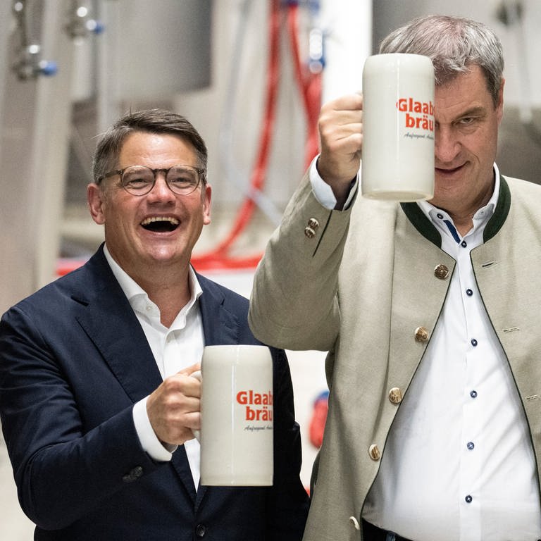 Markus Söder (CSU), Ministerpräsident von Bayern, und Boris Rhein (CDU), Ministerpräsident von Hessen, halten bei der Besichtigung der Brauerei Glaabsbräu in Seligenstadt Bierkrüge in den Händen. (Foto: picture-alliance / Reportdienste, picture alliance/dpa | Boris Roessler)