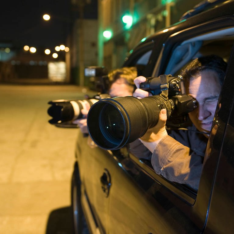 Paparazzi photographer in car. Symbolfoto