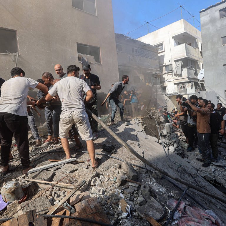 Palästinenser suchen nach Überlebenden in den Trümmern eines Gebäudes nach dem israelischen Bombardement