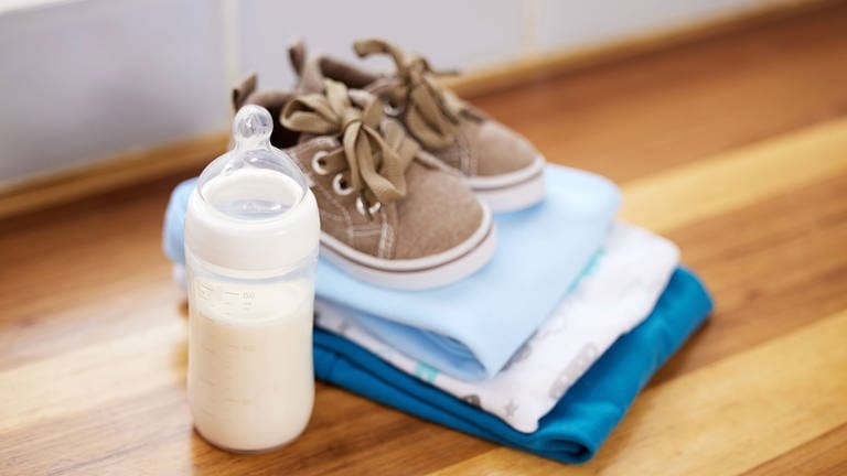 Das neue Baby-Starterpaket - Babykleidung und Milchflasche