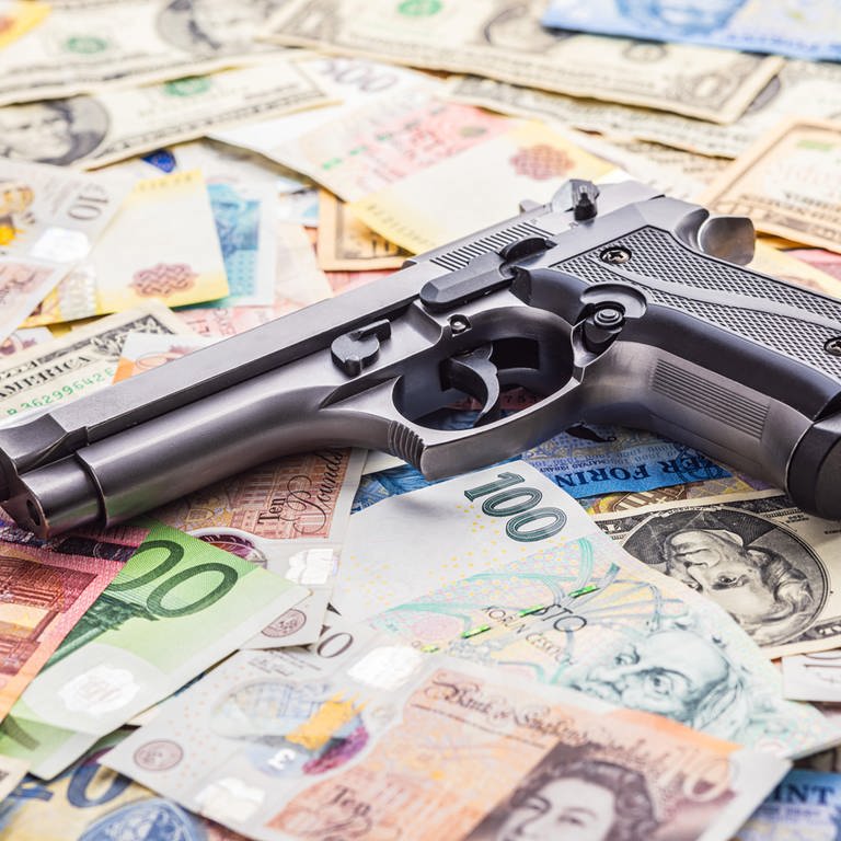 Handgun on the various banknotes background.