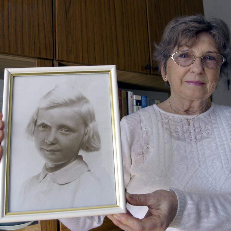 Alodia Witaszek-Napierala, 69, hält ein Foto von sich als Kind in der Hand