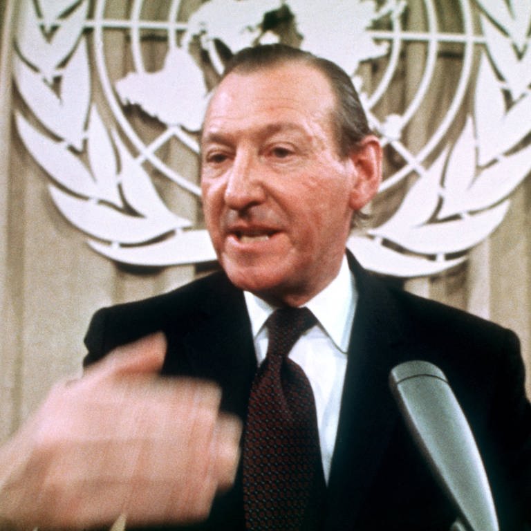 UN-Generalsekretär Kurt Waldheim vor dem Emblem der Vereinten Nationen