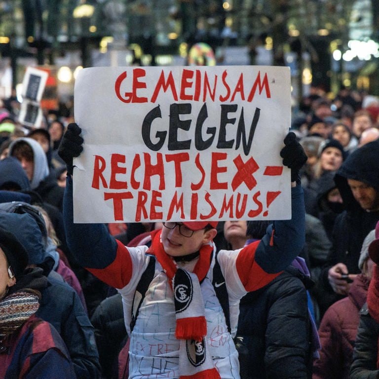 Ein Teilnehmer der Demonstration "Hamburg steht auf" gegen die AFD und Rechtsextremisms hält ein Plakat mit der Aufschrift "Gemeinsam gegen Rechtsextremismus".