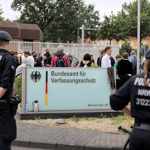 Vor dem Bundesamt für Verfassungsschutz in Köln stehen Demonstranten und Polizisten